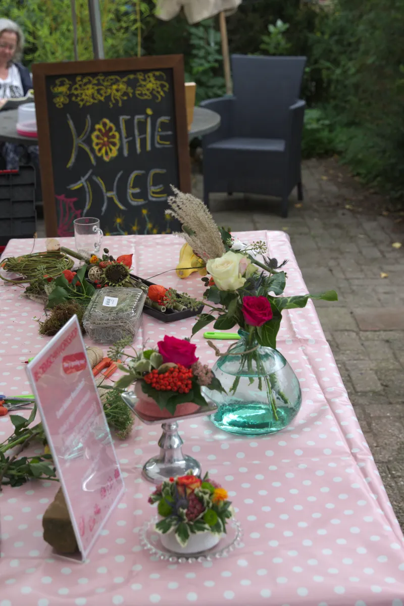 Bezoekers praten na in de koffie- en theetuin van Harco Kwekerij