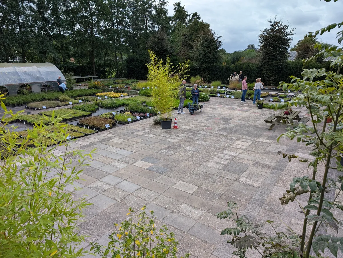 Bezoekers lopen tussen de kweektafels met vaste planten