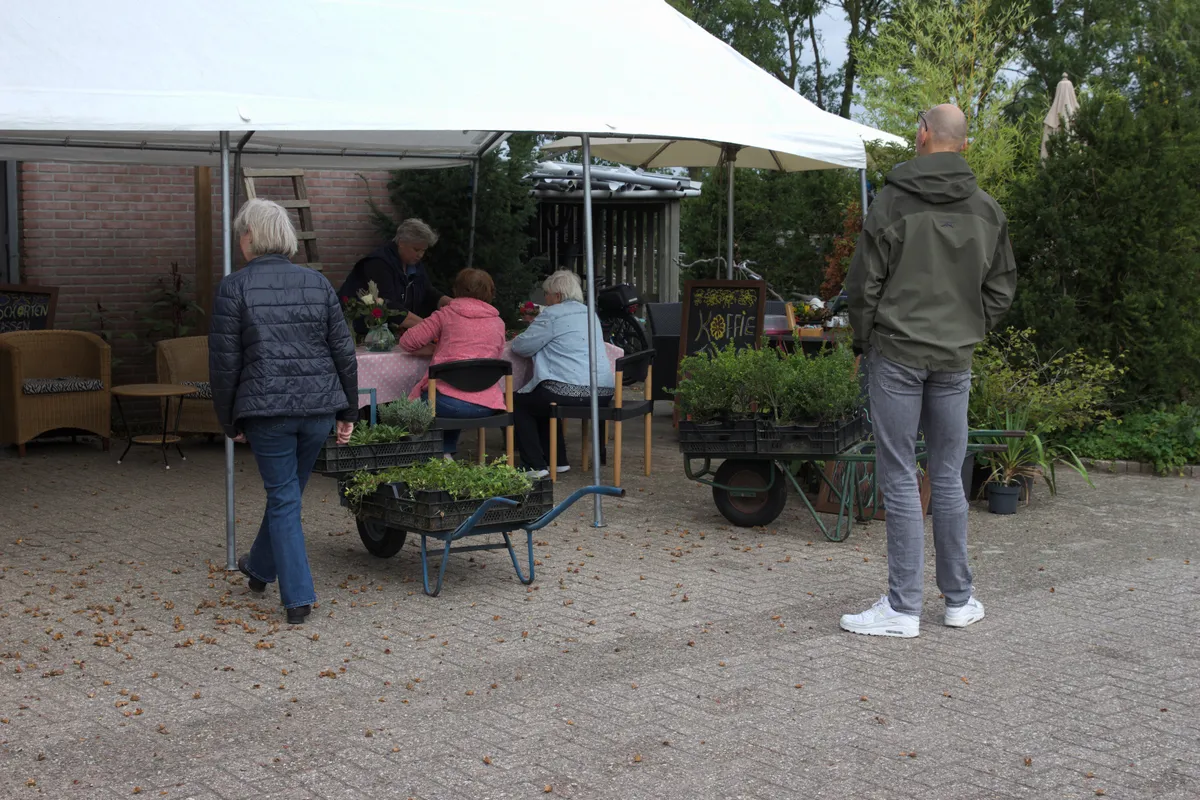 Bezoekers schikken bloemen na het uitzoeken van inheemse beplanting
